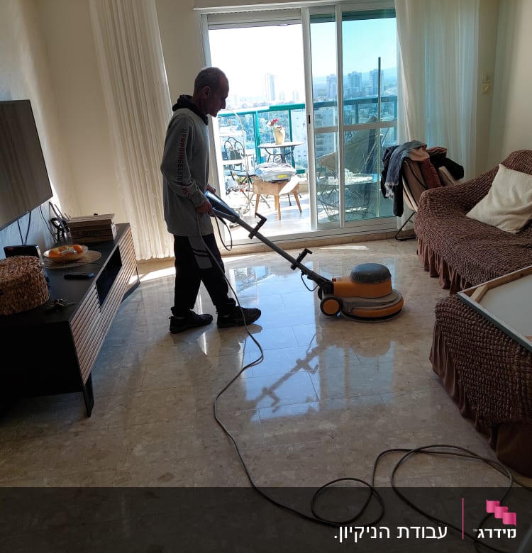 אדם מנקה רצפה עם מכונת פוליש חשמלית